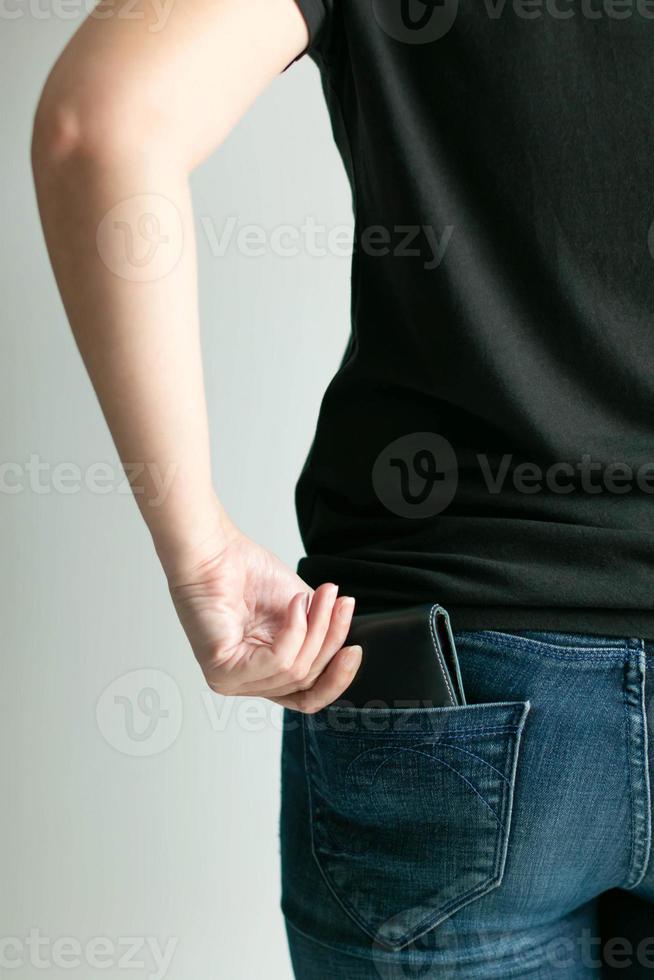 A woman bring out money wallet from jeans pocket. photo