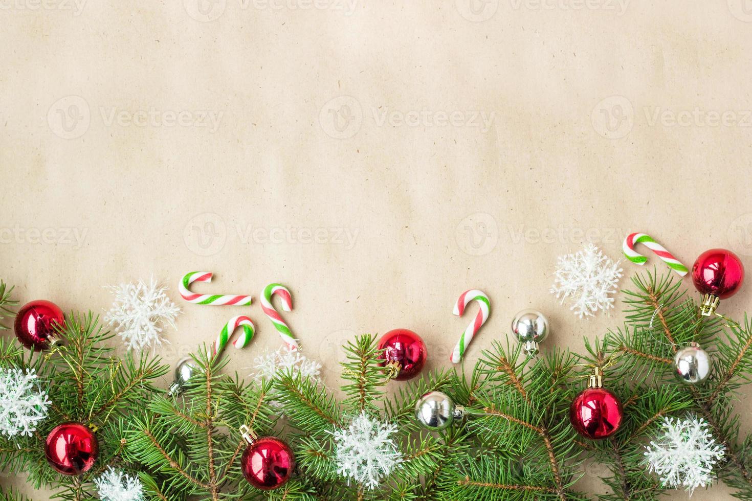 Festive christmas border with red and silver balls on fir branches and snowflakes on rustic beige background photo