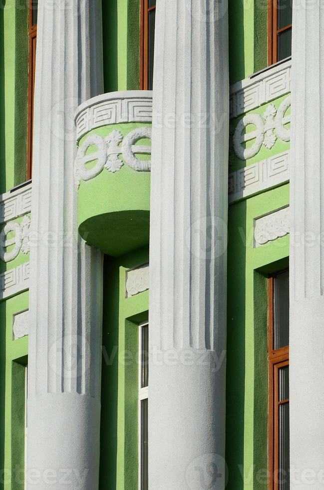 antiguo edificio restaurado de varias plantas con columnas antiguas, pintado de verde foto