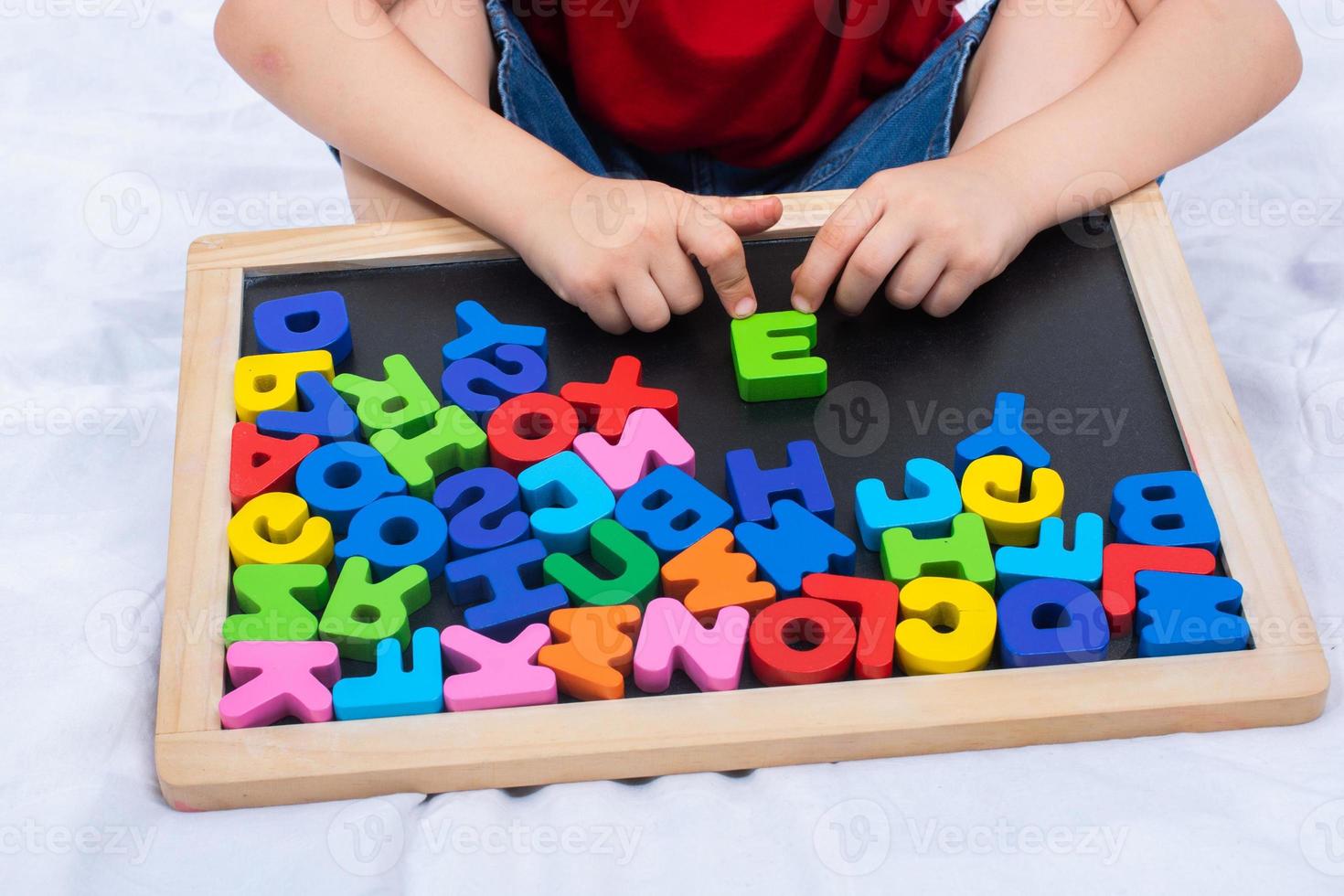 niño pequeño y coloridos bloques de letras del alfabeto como concepto de educación foto