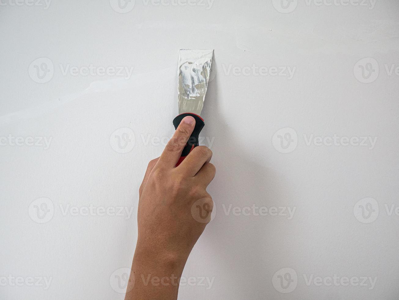 Plasterer hand repair crack white wall photo