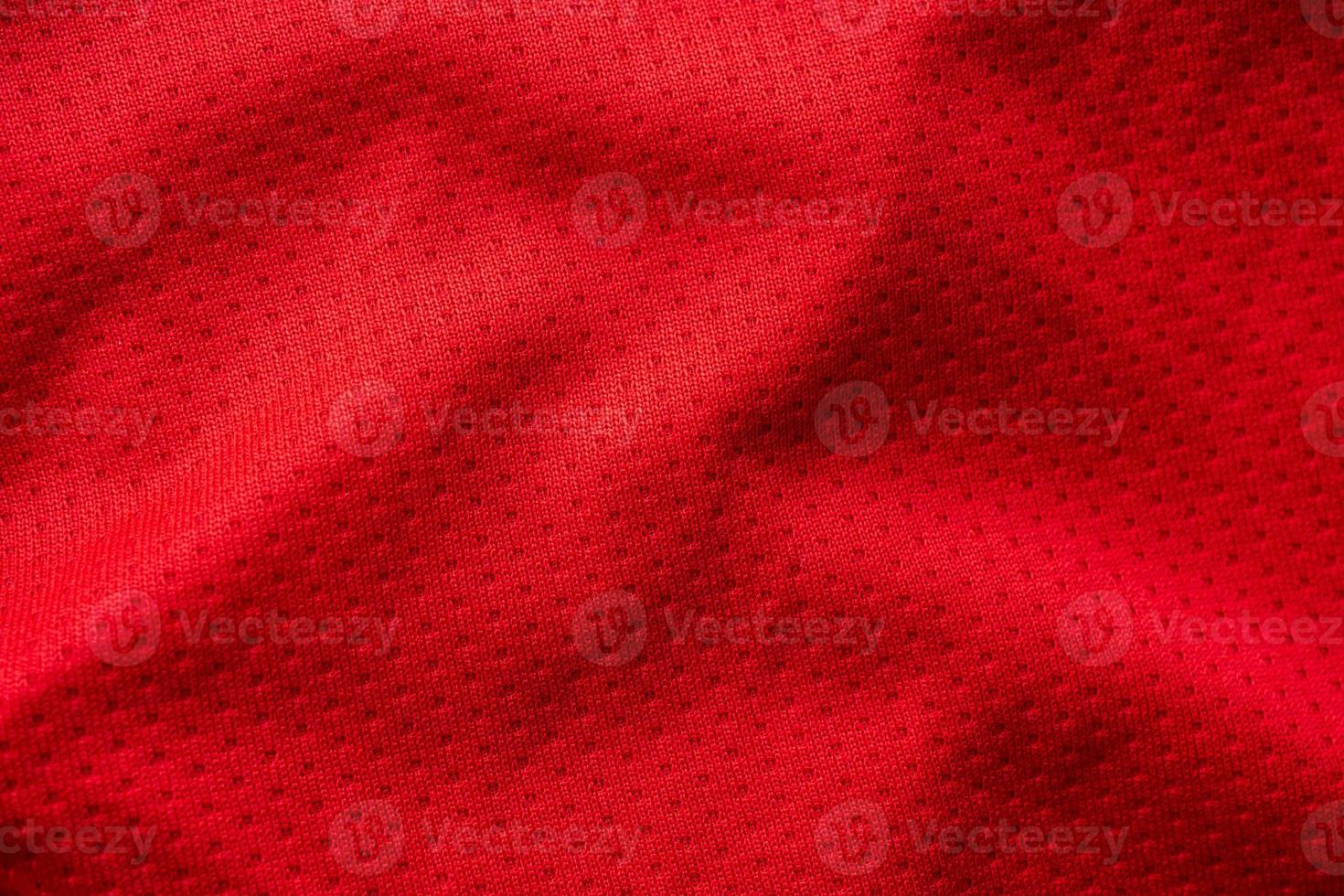 Red fabric sport clothing football jersey with air mesh texture background photo