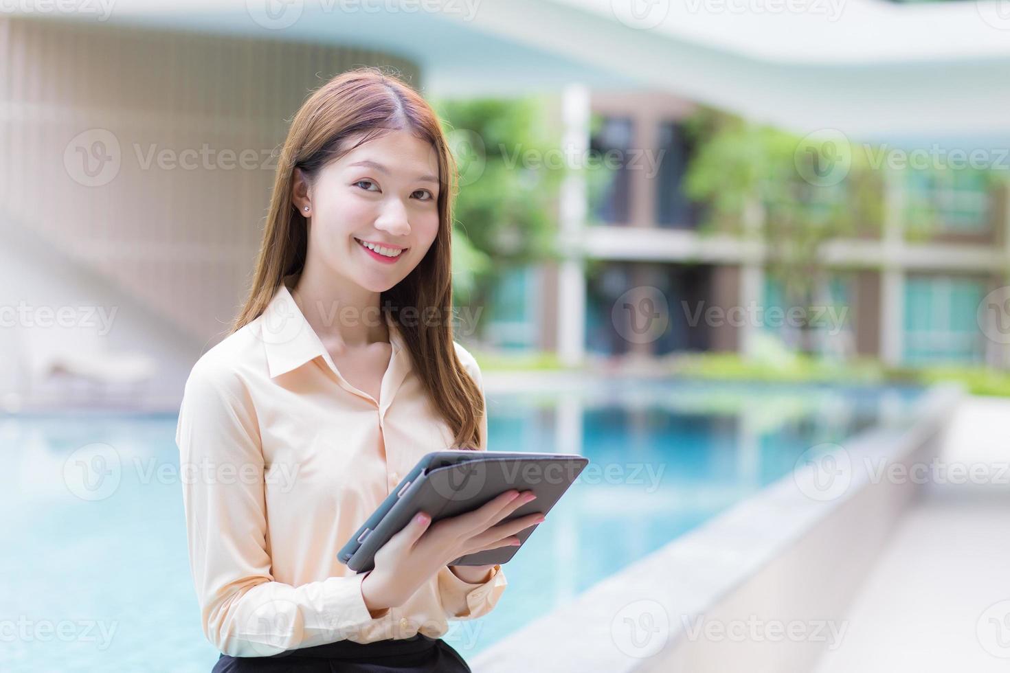 Asian beautiful working female uses tablet to search data in working from anywhere concept. photo