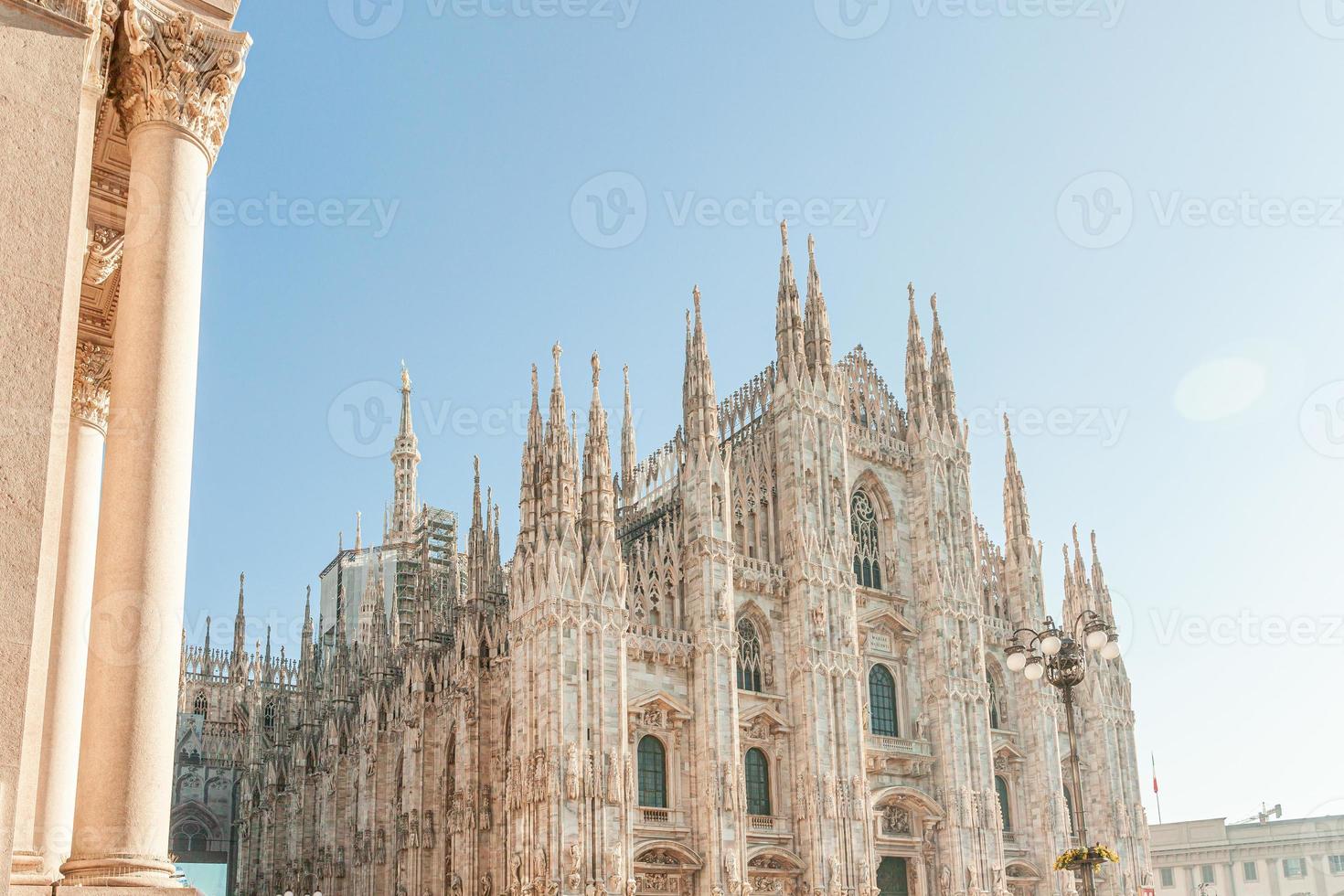 Famous church Milan Cathedral Duomo di Milano with Gothic spires and white marble statues. Top tourist attraction on piazza in Milan Lombardia Italy. Wide angle view of old Gothic architecture and art photo