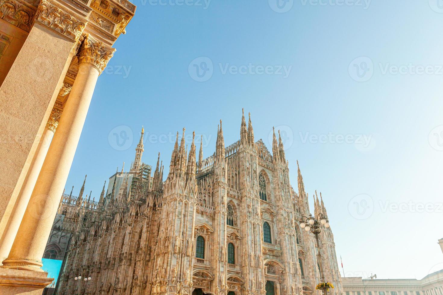 Famous church Milan Cathedral Duomo di Milano with Gothic spires and white marble statues. Top tourist attraction on piazza in Milan Lombardia Italy. Wide angle view of old Gothic architecture and art photo