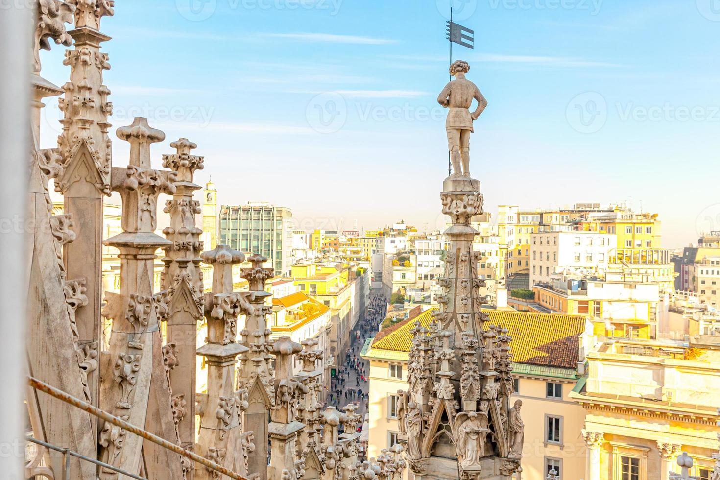 Roof of Milan Cathedral Duomo di Milano with Gothic spires and white marble statues. Top tourist attraction on piazza in Milan, Lombardia, Italy. Wide angle view of old Gothic architecture and art. photo