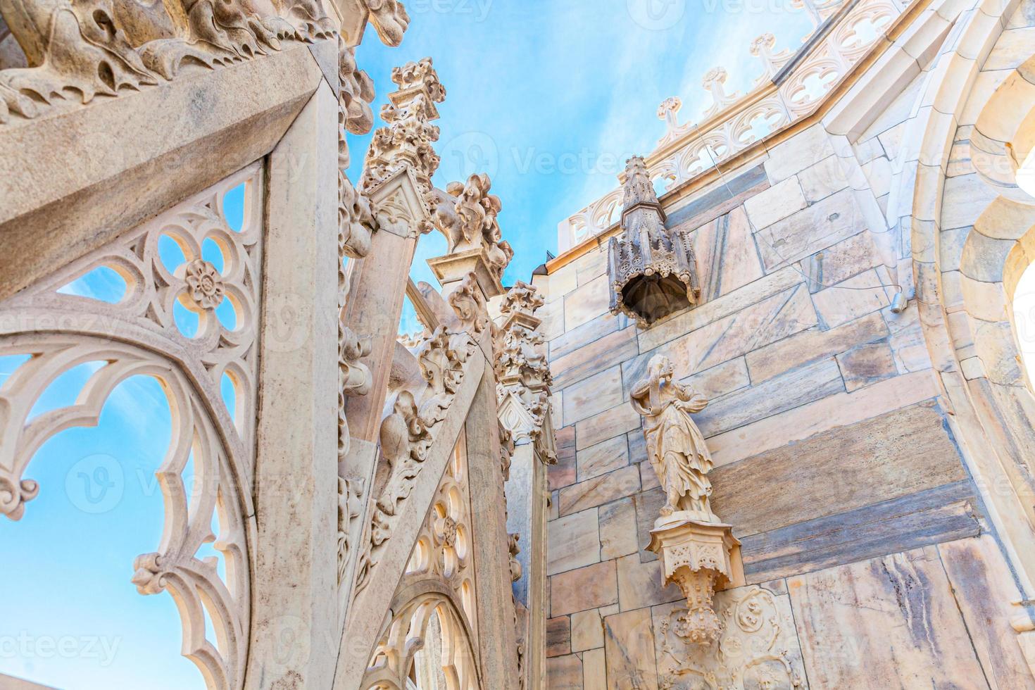 techo de la catedral de milán duomo di milano con agujas góticas y estatuas de mármol blanco. principal atracción turística en la plaza de milán, lombardía, italia. vista panorámica de la antigua arquitectura gótica y el arte. foto