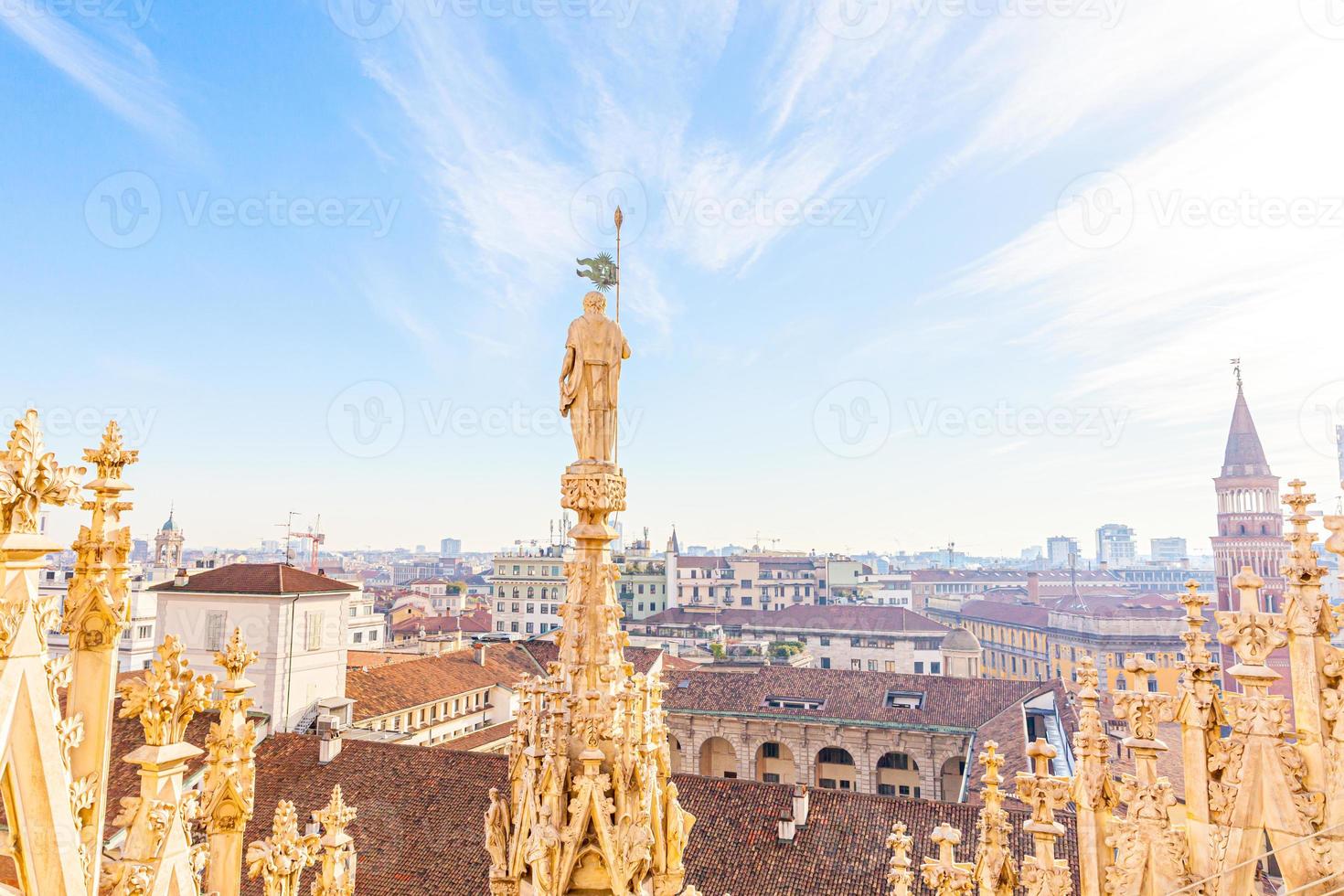 Roof of Milan Cathedral Duomo di Milano with Gothic spires and white marble statues. Top tourist attraction on piazza in Milan, Lombardia, Italy. Wide angle view of old Gothic architecture and art. photo