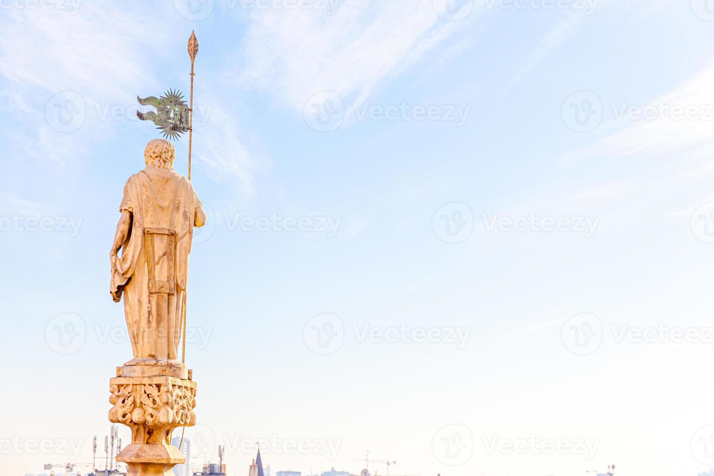 Roof of Milan Cathedral Duomo di Milano with Gothic spires and white marble statues. Top tourist attraction on piazza in Milan, Lombardia, Italy. Wide angle view of old Gothic architecture and art. photo