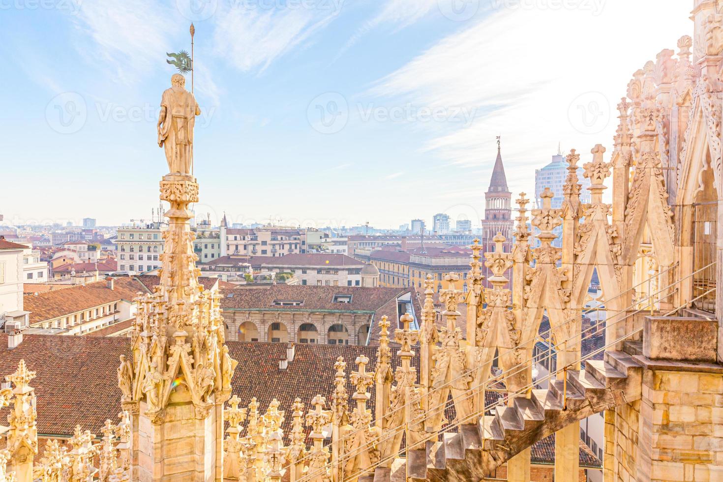 Roof of Milan Cathedral Duomo di Milano with Gothic spires and white marble statues. Top tourist attraction on piazza in Milan, Lombardia, Italy. Wide angle view of old Gothic architecture and art. photo