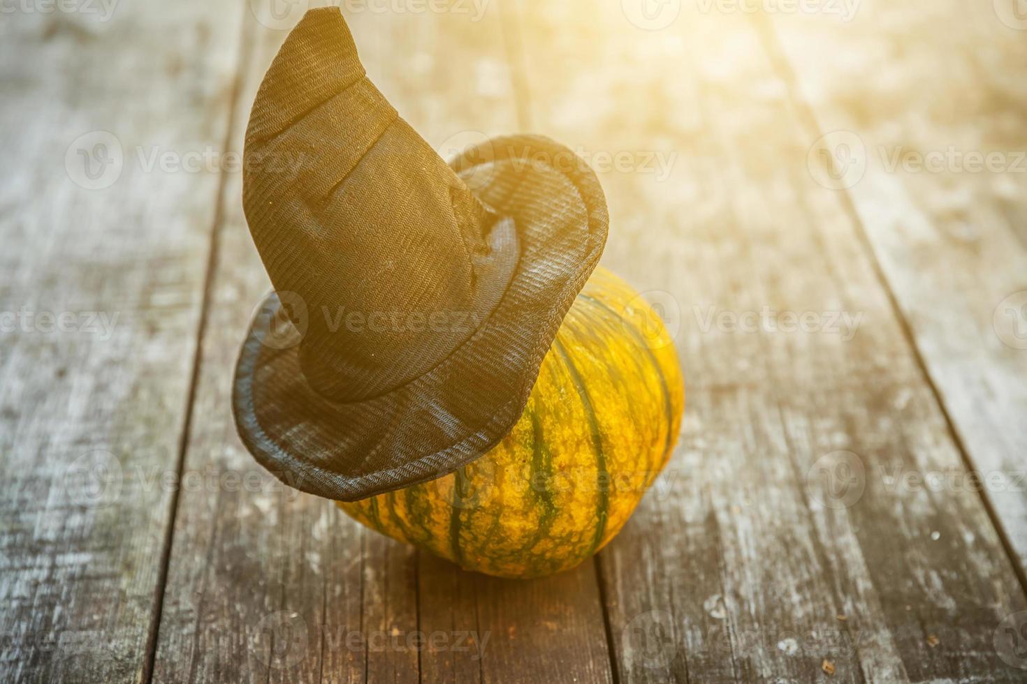 Jack O Lantern Halloween pumpkin with black witch hat on wooden background. Halloween party concept. Holiday season greeting, trick of treat spooky. photo