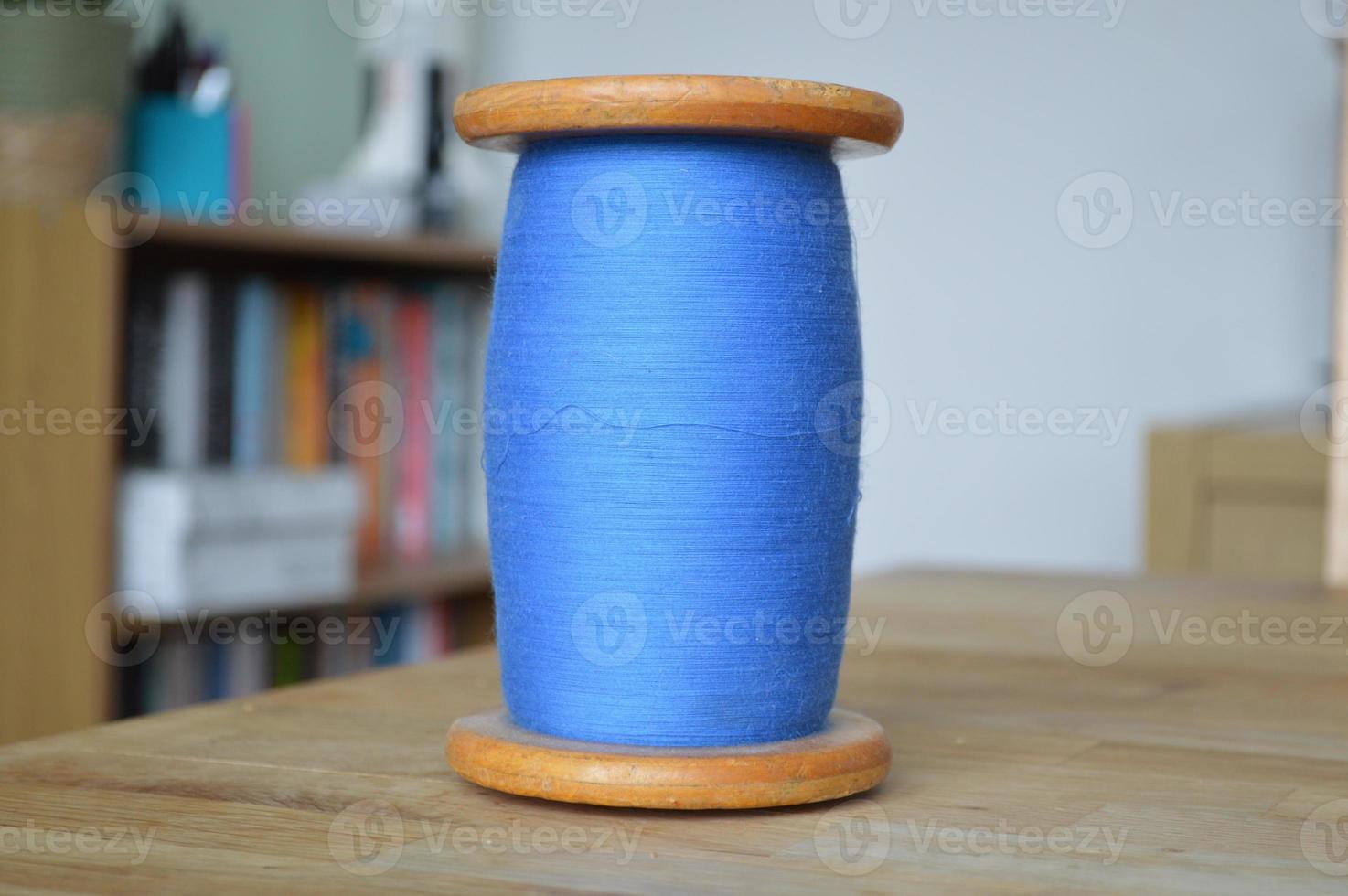 Blue Cotton Bobbin on a Wooden Table photo