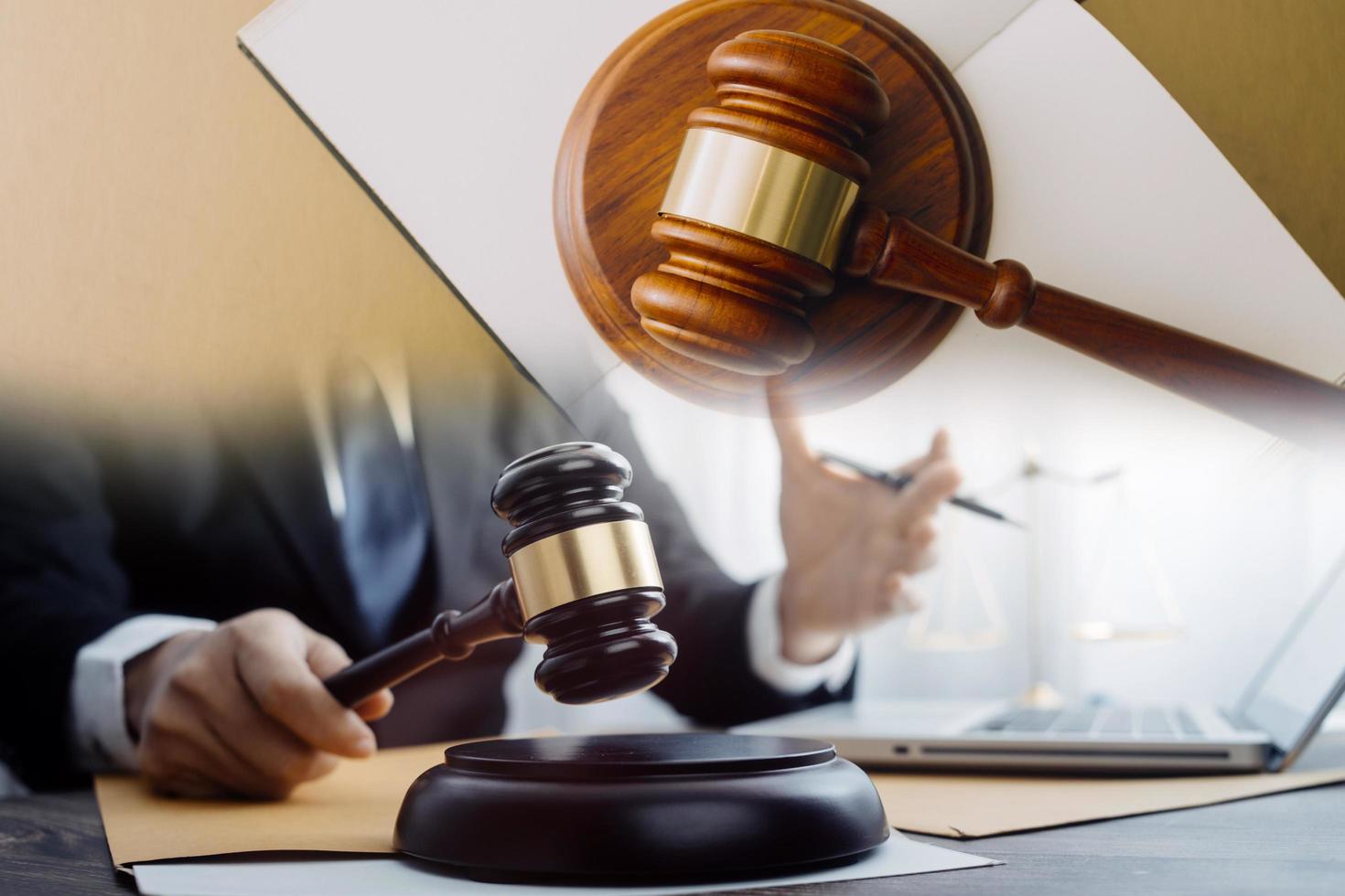 Justice and law concept.Male judge in a courtroom with the gavel, working with, computer and docking keyboard, eyeglasses, on table in morning light photo