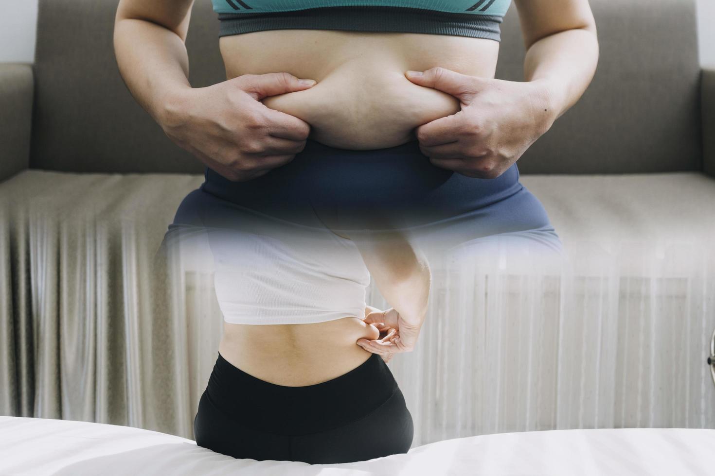 Beautiful fat woman with tape measure She uses her hand to squeeze the excess fat that is isolated on a white background. She wants to lose weight, the concept of surgery and break down fat under the photo