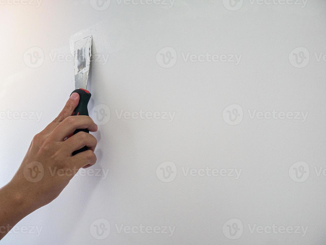 Plasterer hand repair crack white wall photo