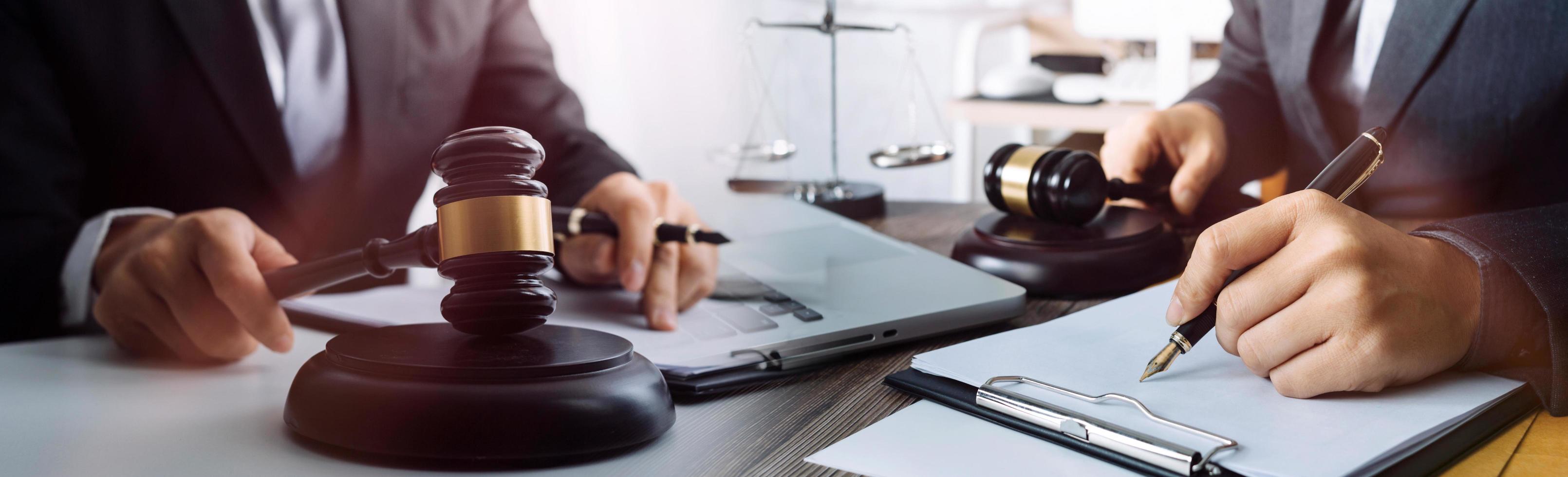 abogado masculino que trabaja con papeles de contrato y mazo de madera en tabel en la sala del tribunal. justicia y derecho, abogado, juez de la corte, concepto. foto