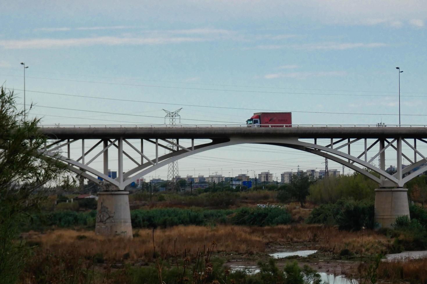 Modern bridge over a river over which large vehicles and tourists pass. photo