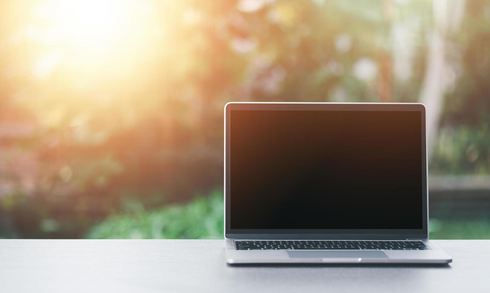 laptop on desk, beautiful nature background in the morning, bright start concept, relaxation, backyard work photo