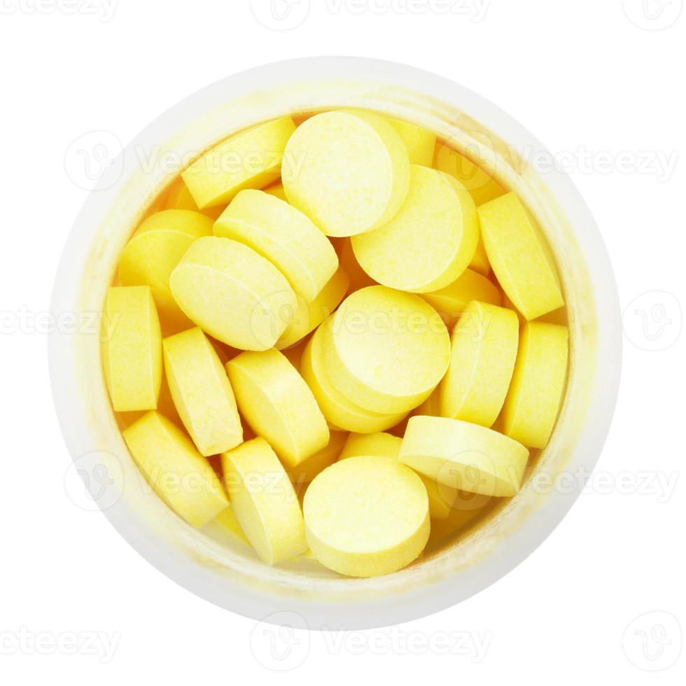 top view of yellow pills in round plastic bottle photo