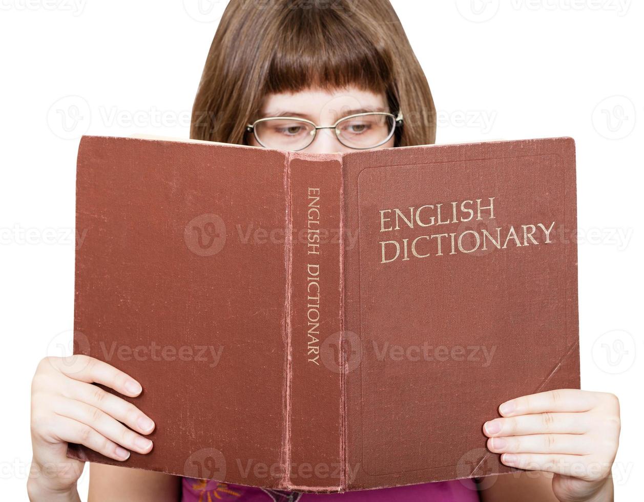 Chica con gafas lee el libro del diccionario de inglés foto