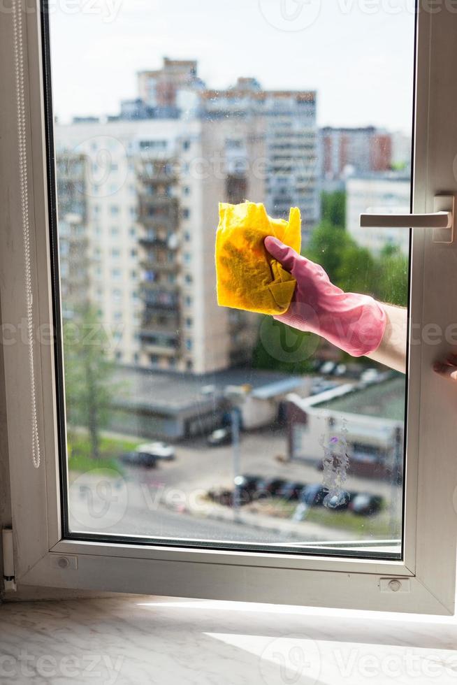 washer cleans window by rag in apartment house photo