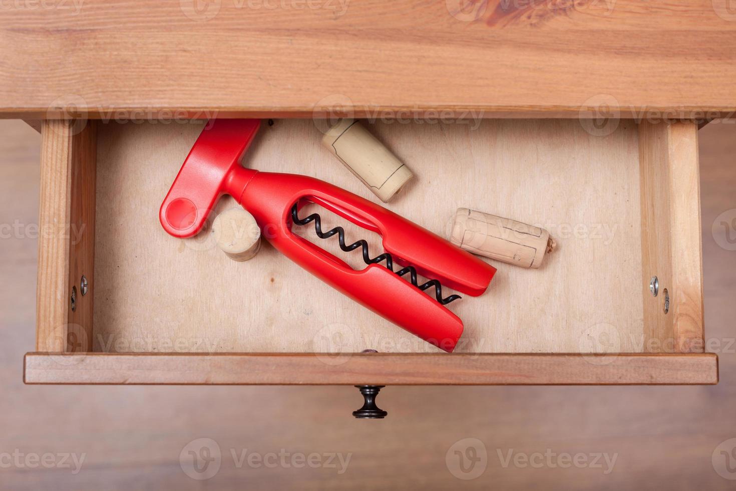 red corkscrew and cork from wine bottles in drawer photo