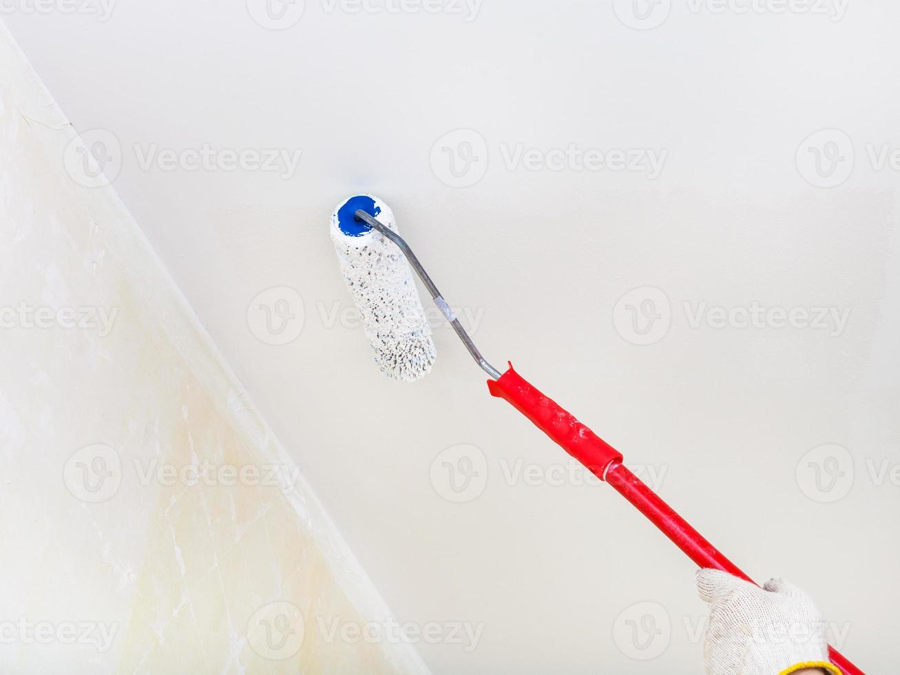 painter paints the ceiling with white paint photo