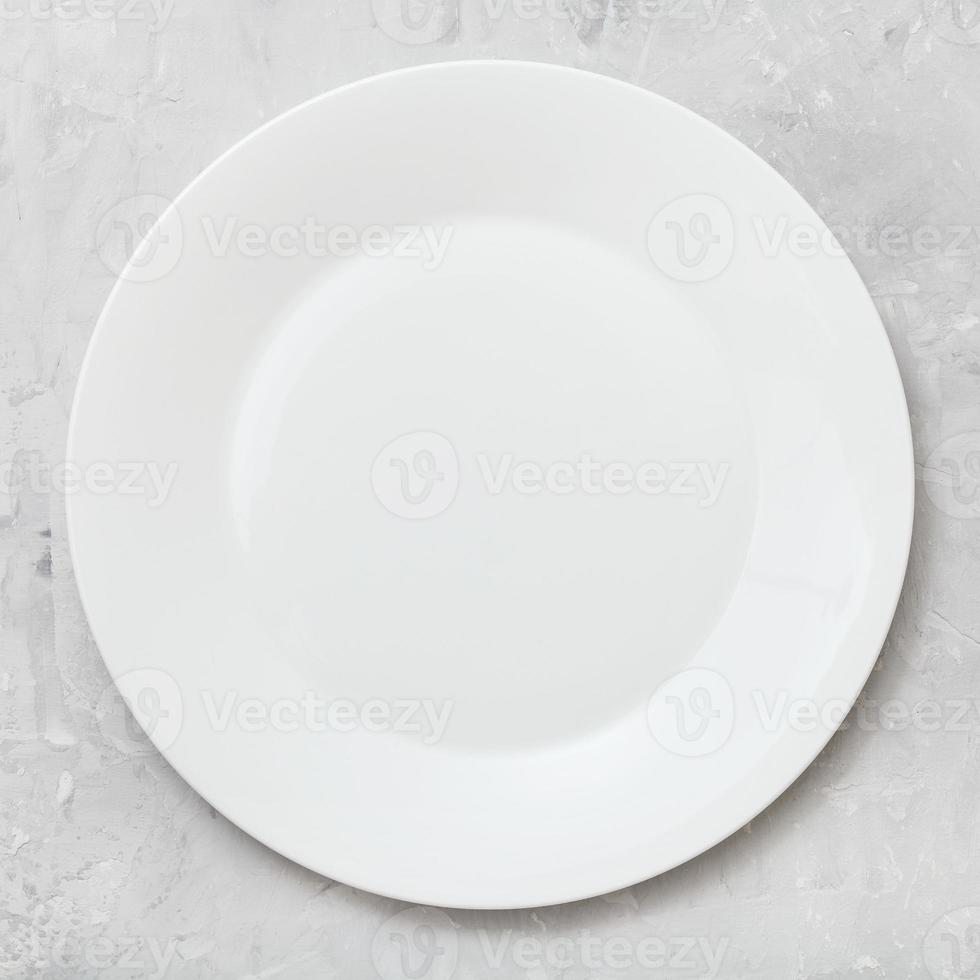 top view of white plate on gray concrete surface photo