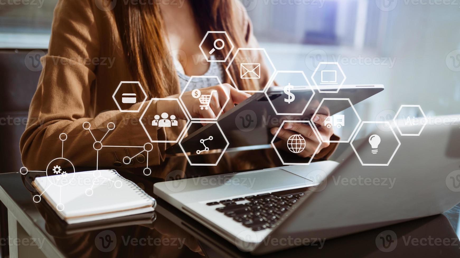 Hands using mobile phone in modern office with laptop working digital marketing media in virtual screen photo