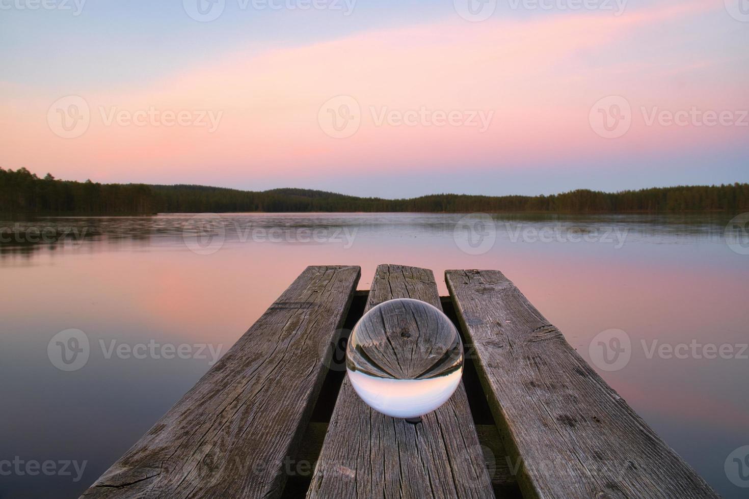 Glass ball on a wooden pier at a Swedish lake at evening hour. Nature Scandinavia photo