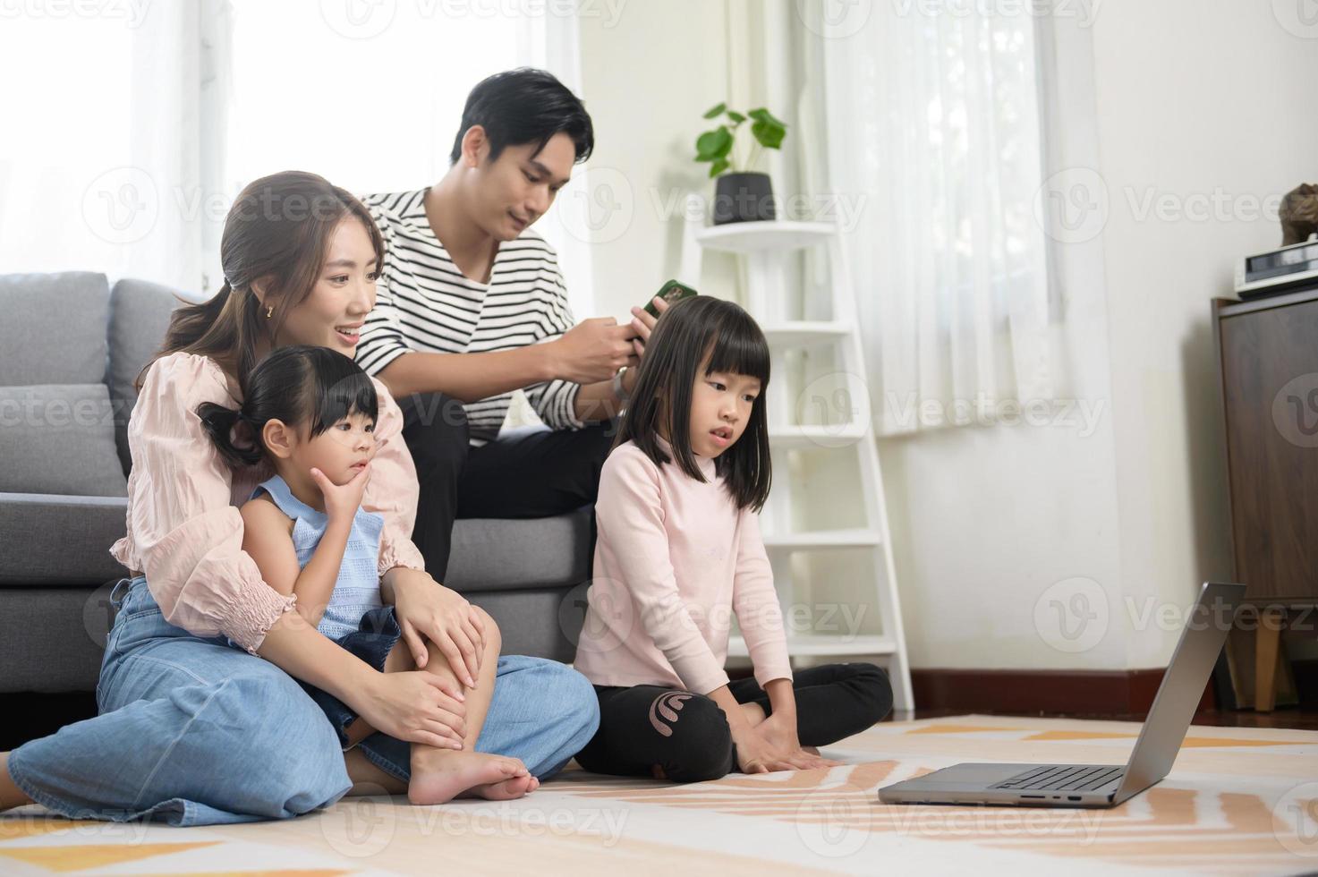 Asian family with children using laptop computer at home photo