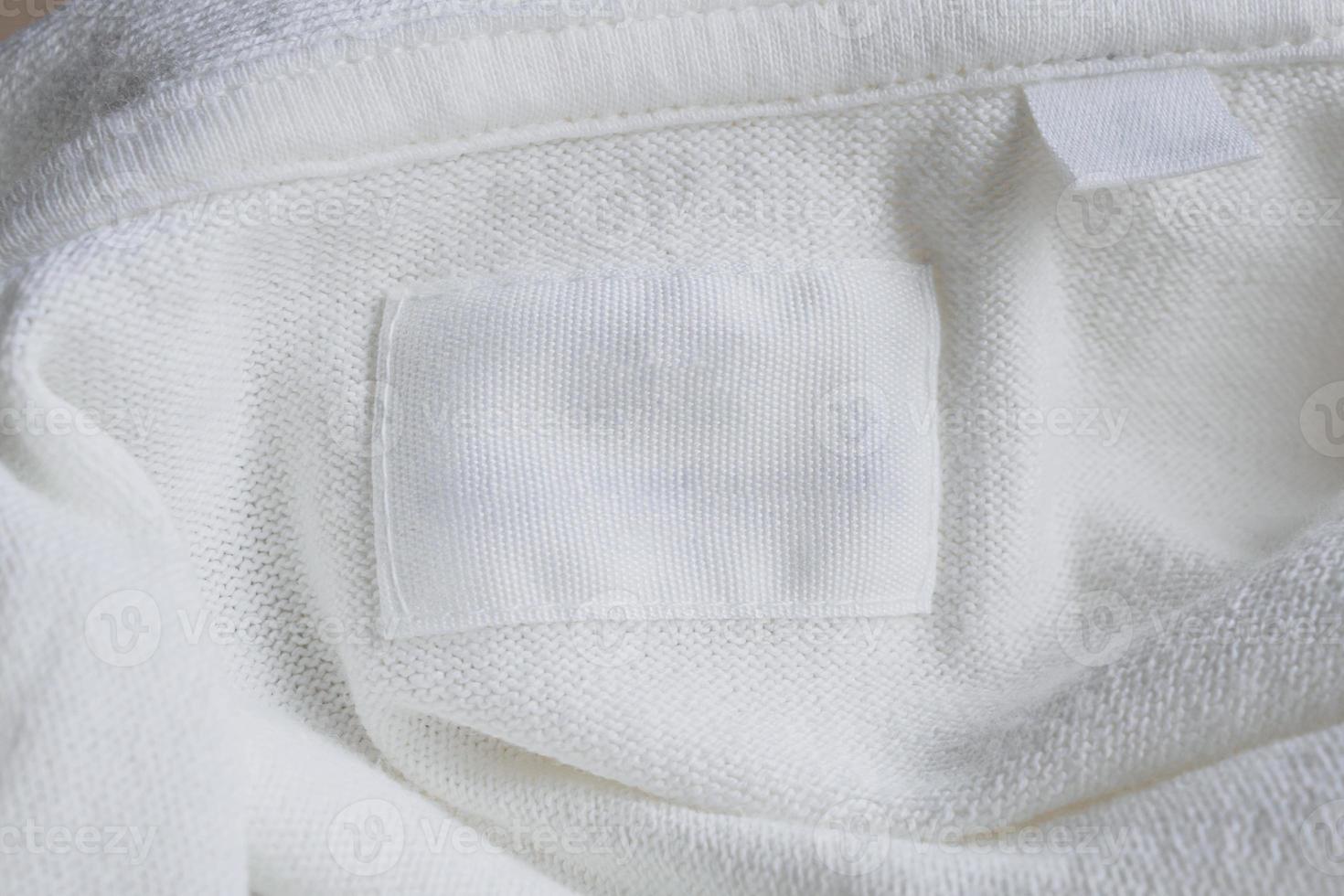 Blank white clothes label on new cotton shirt background photo