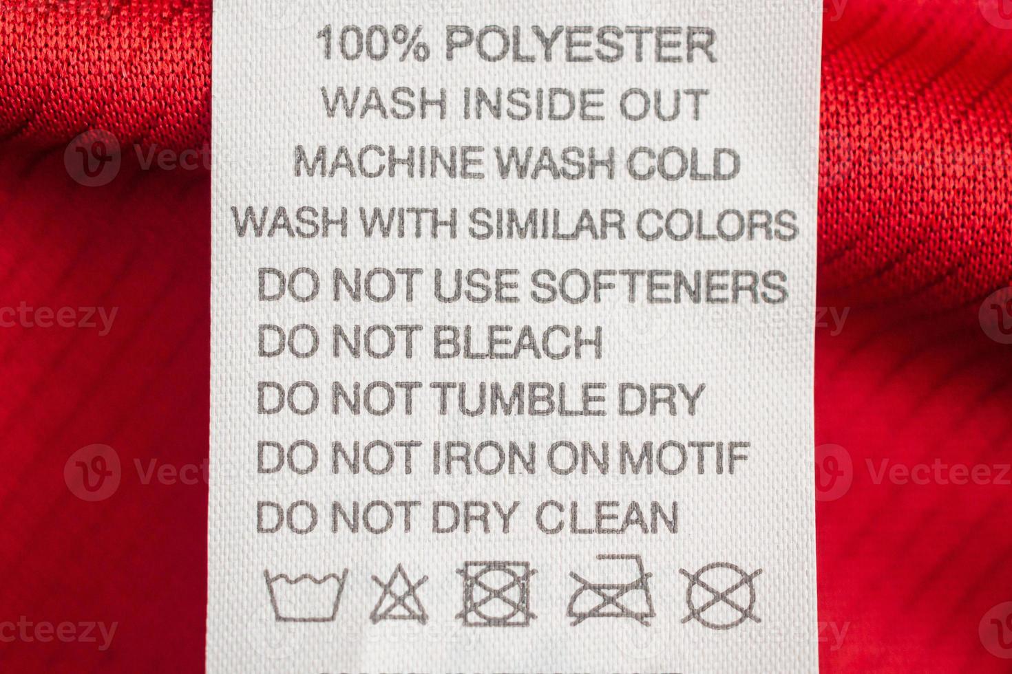 White laundry care washing instructions clothes label on red jersey polyester sport shirt photo