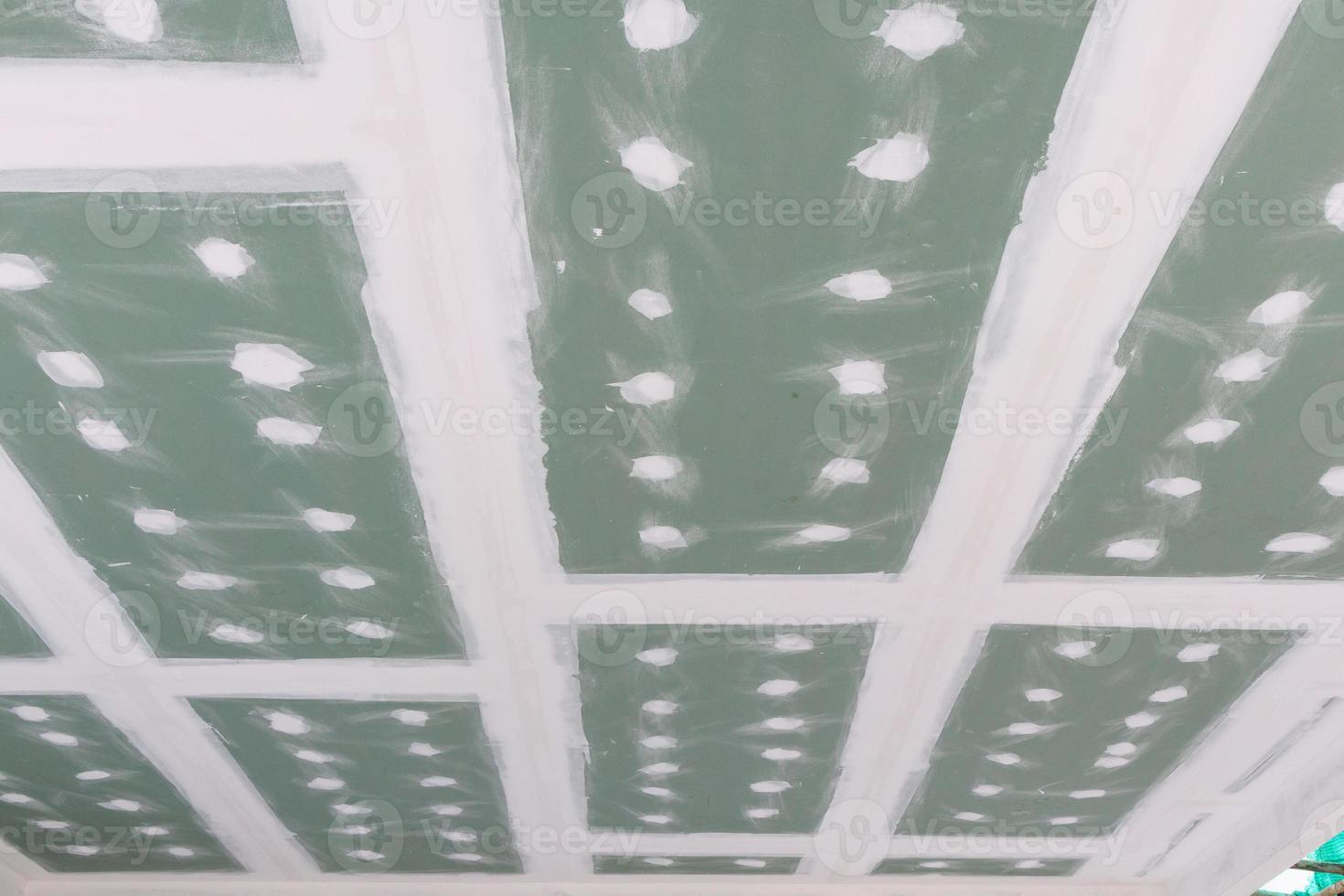 ceiling gypsum board installation at construction site photo