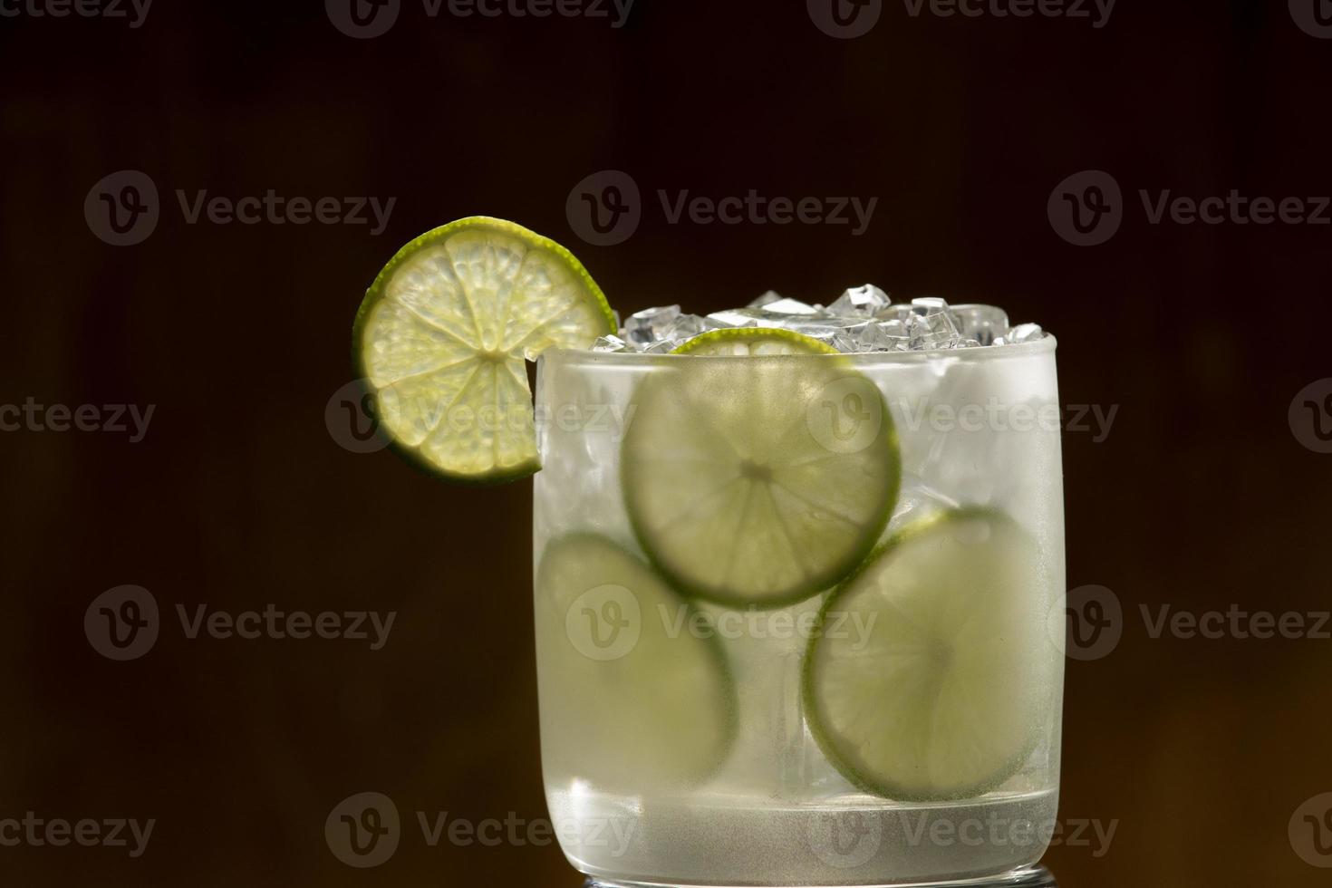 Tom Collins cocktail in a black background, eco-friendly metal straw photo