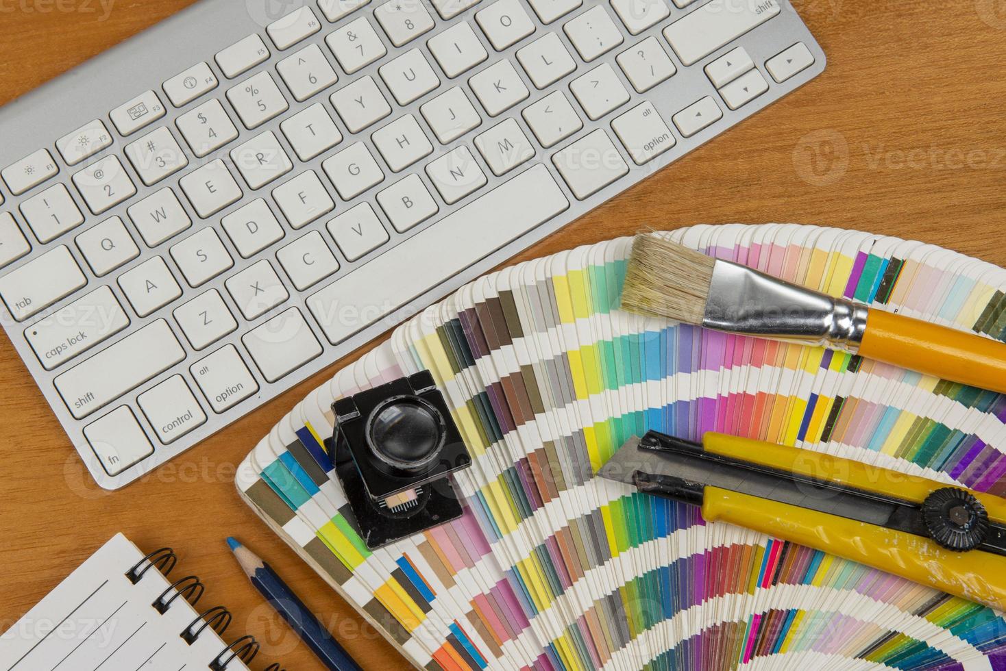 color scale with stylus and magnifying glass on it and a notebook photo