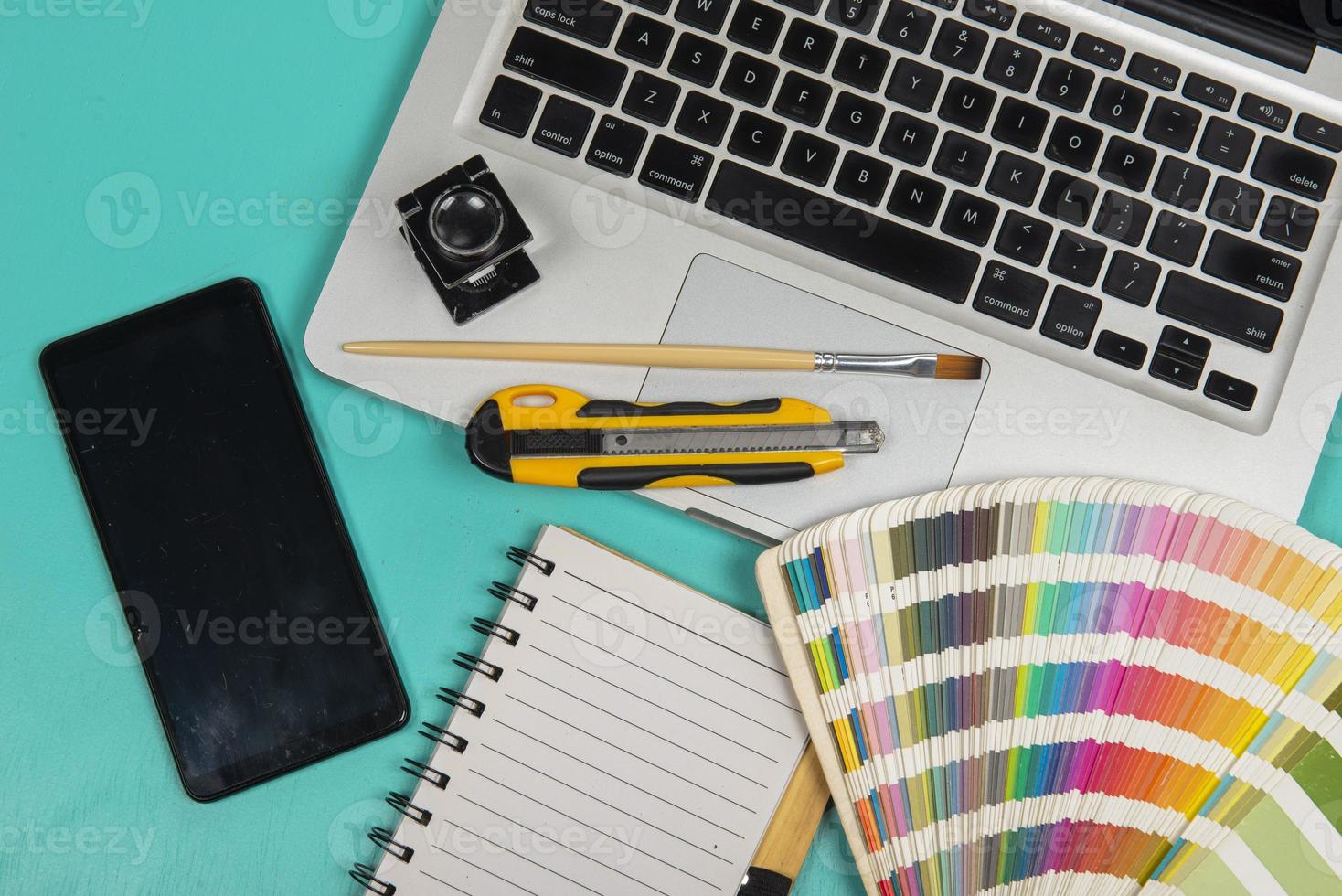 color scale with stylus and magnifying glass on it and a notebook photo