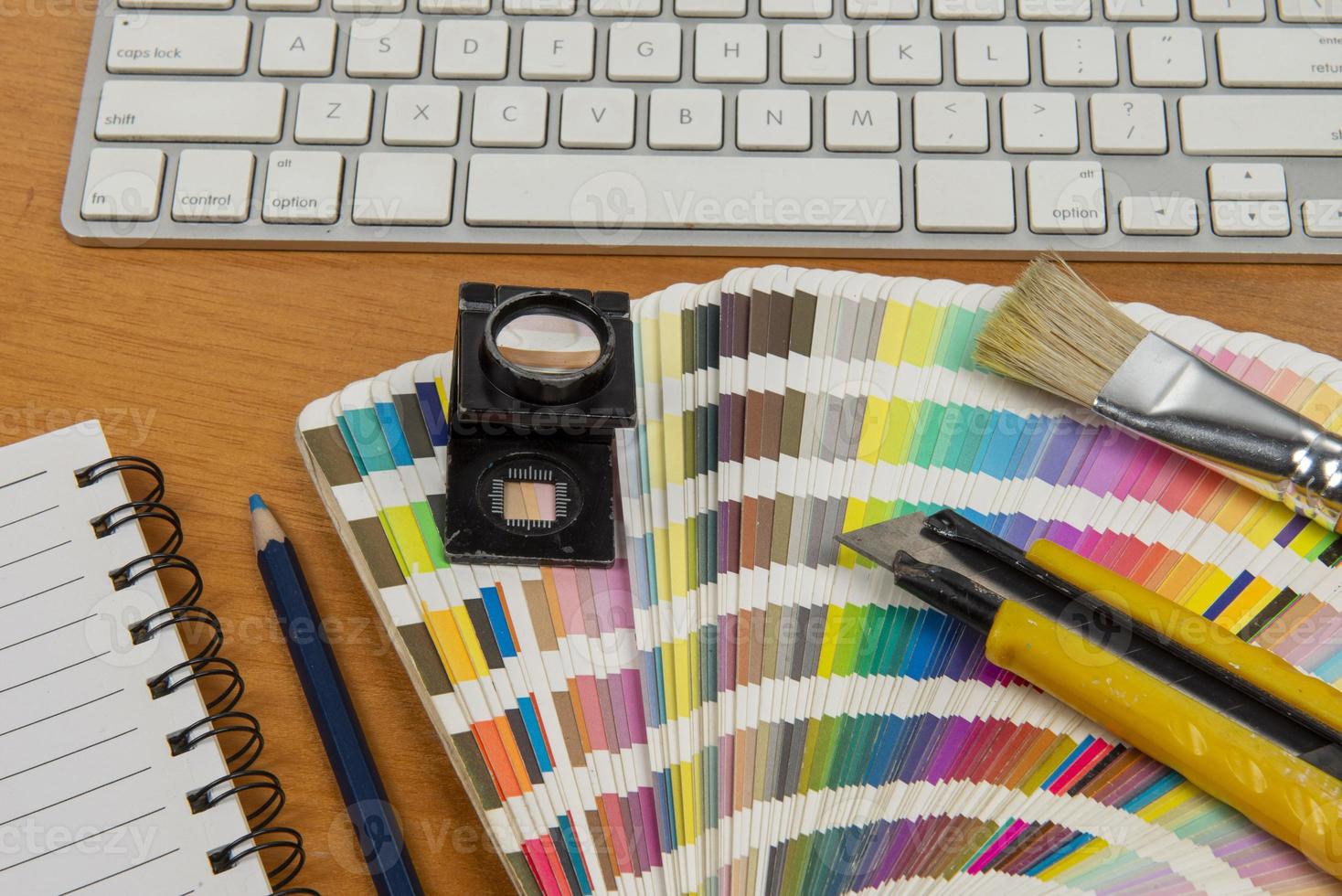 color scale with stylus and magnifying glass on it and a notebook photo