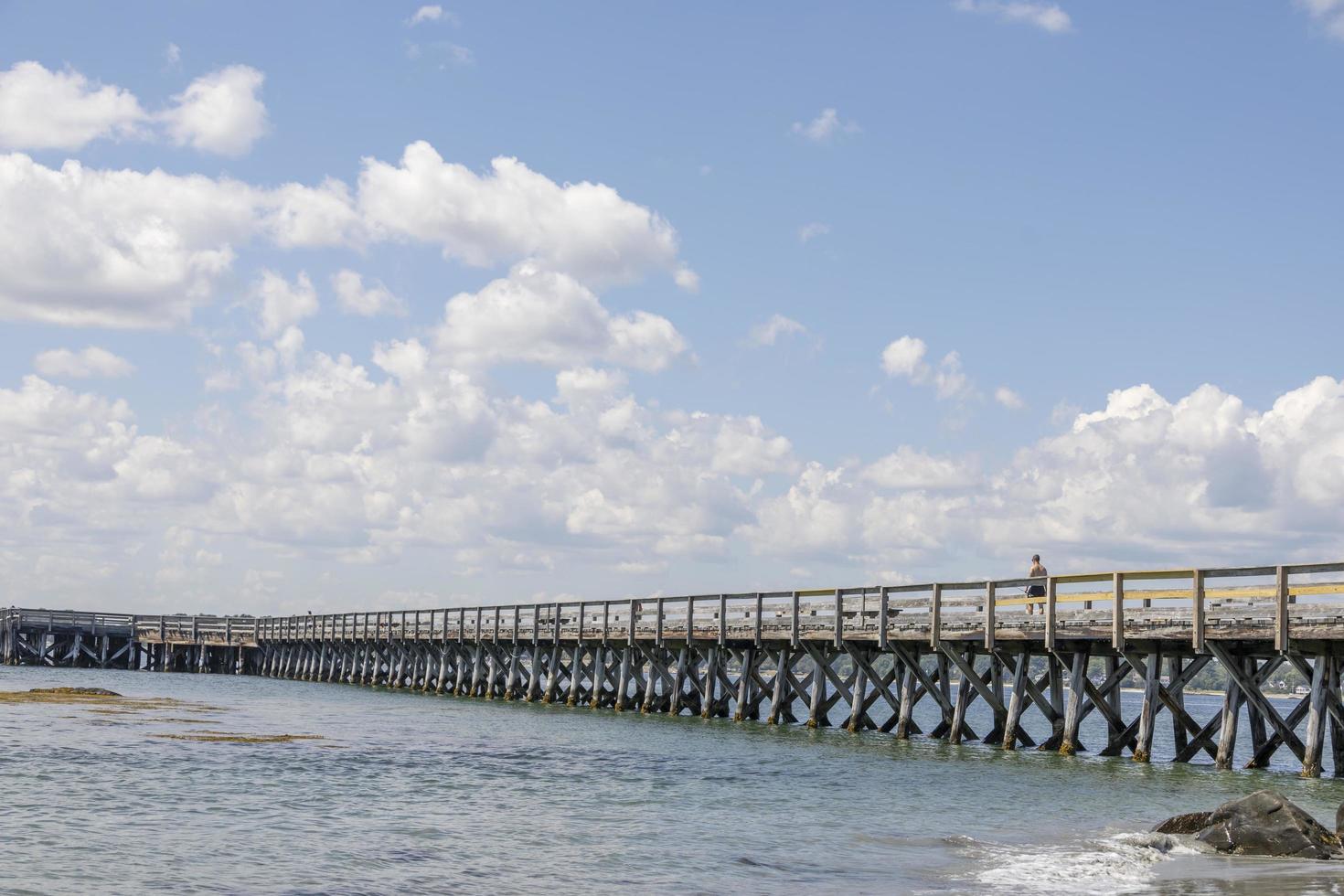 Wooden pier by the beach and ocean in the summer photo