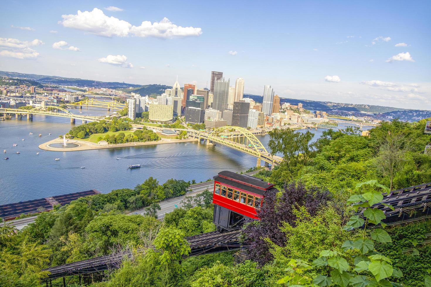 Red tram going down an incline in a city photo