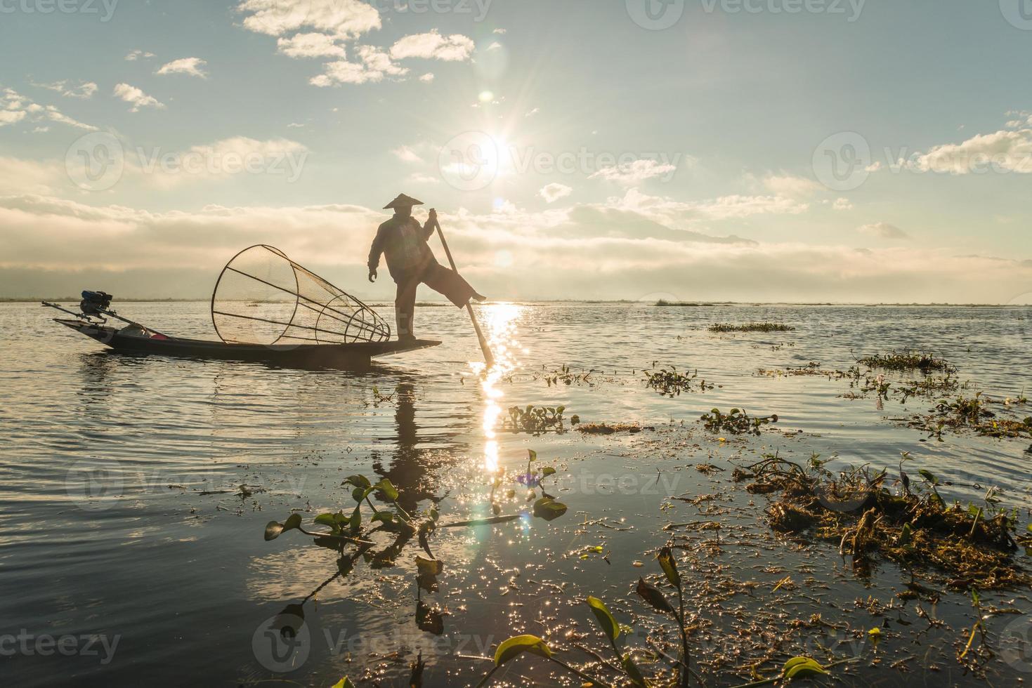 la silueta del pescador intha del lago inle, myanmar. los intha son las únicas personas en el mundo que pescan con una sola pierna. foto