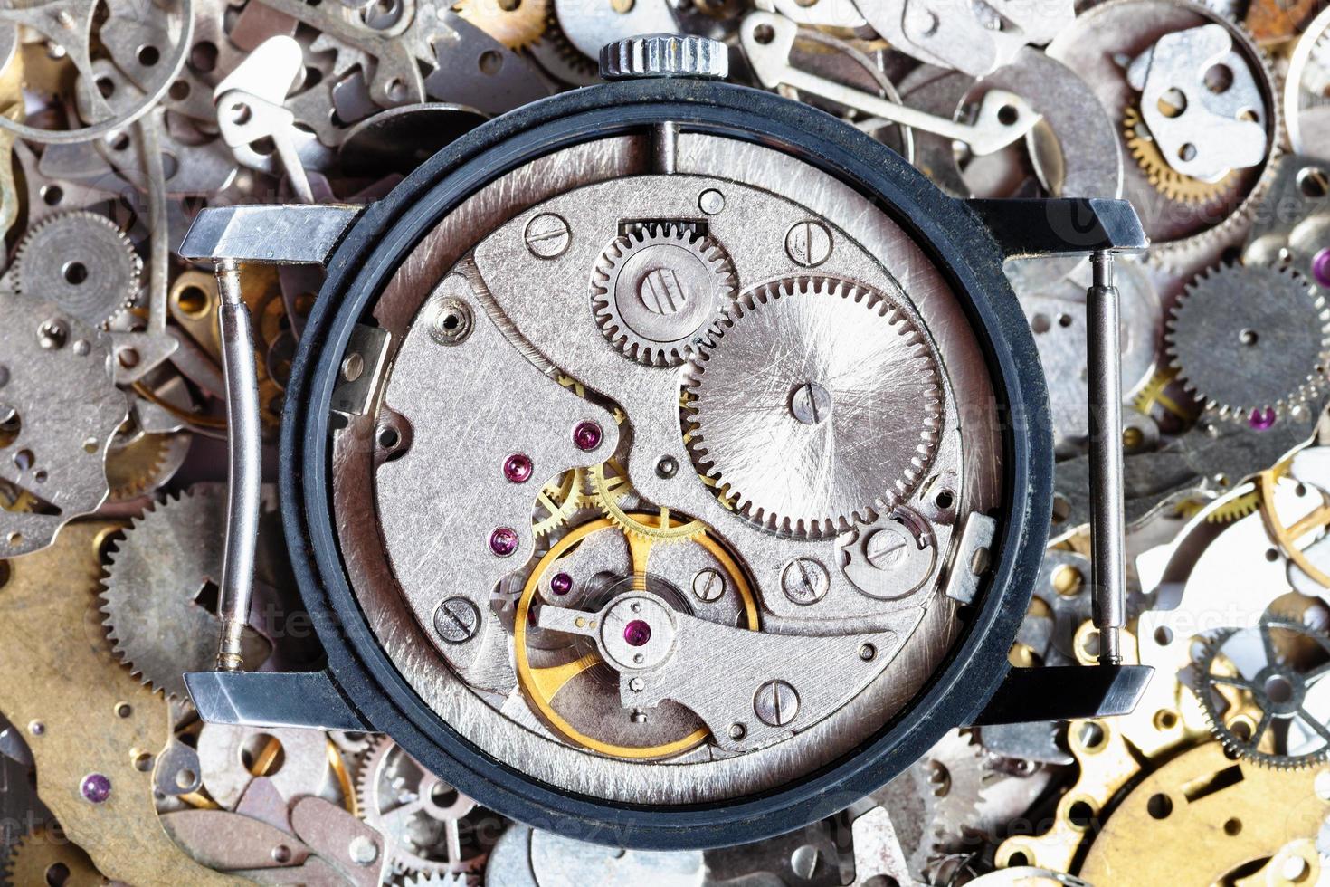 open vintage watch on heap of clock spare parts photo