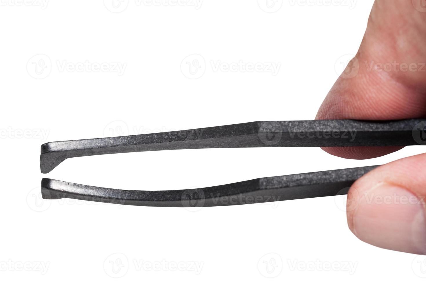 los dedos masculinos sostienen pinzas de plástico negro foto