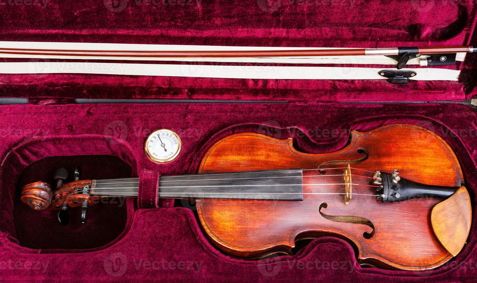 top view of old violin with bow in red velvet case photo