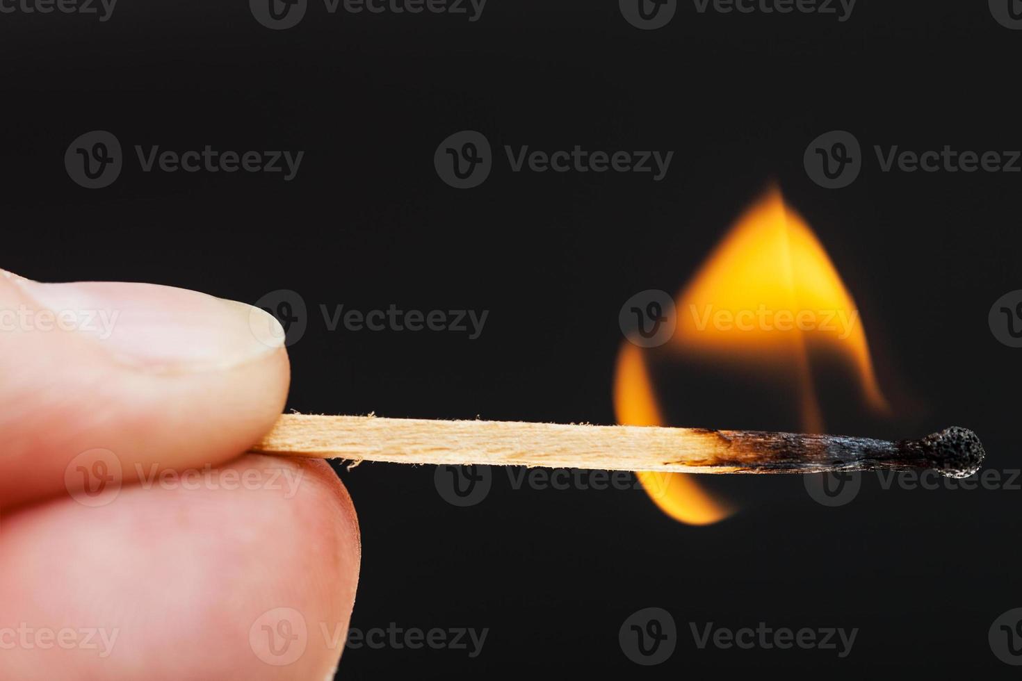 fingers with burning wooden match photo