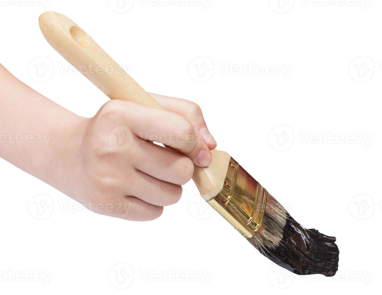 painter hand holds brush with black paint photo