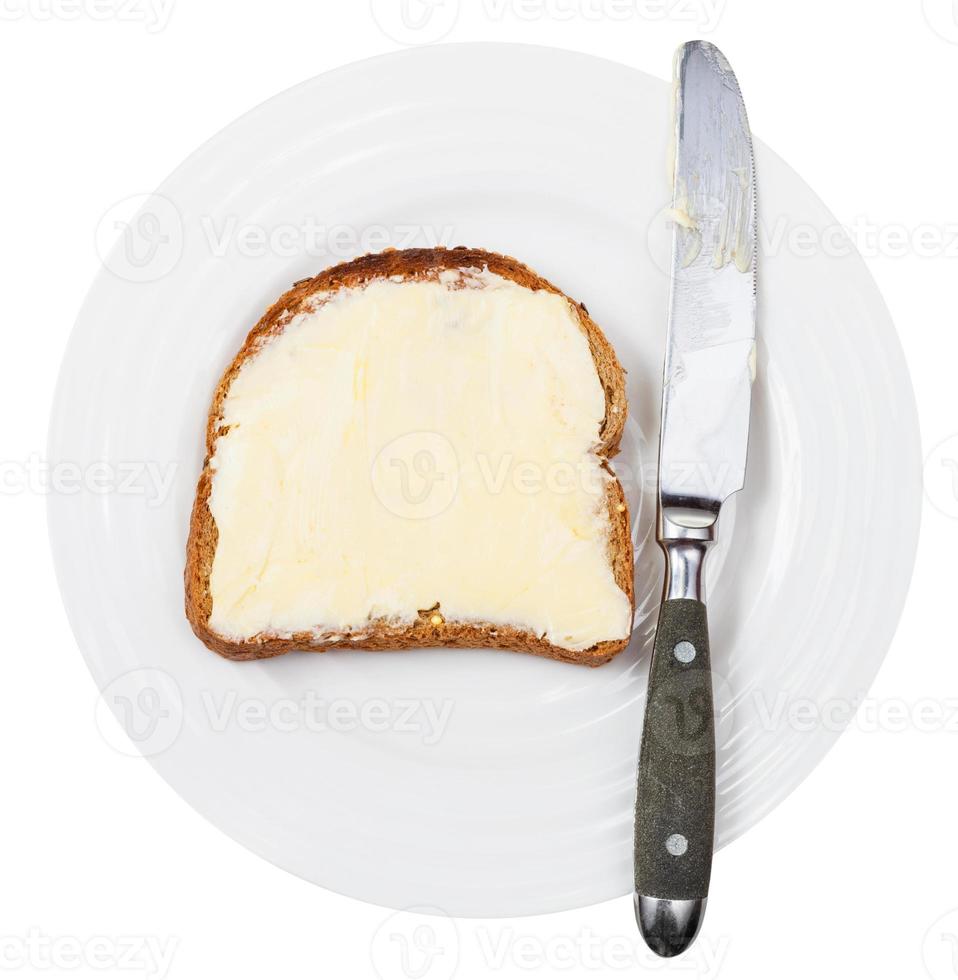 top view of knife and bread and butter on plate photo