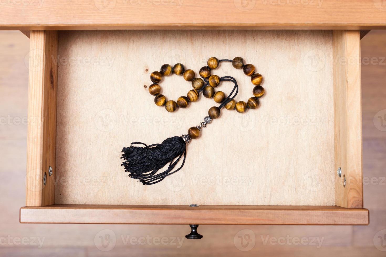 rosary from tigers eye gemstone in open drawer photo