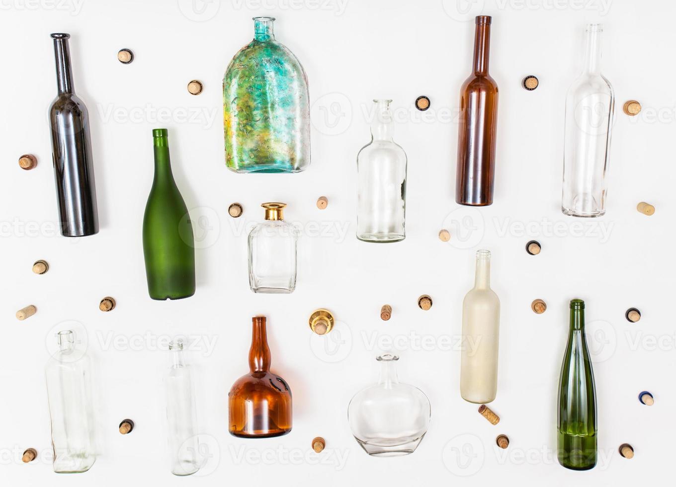 many empty glass bottles and corks on white photo