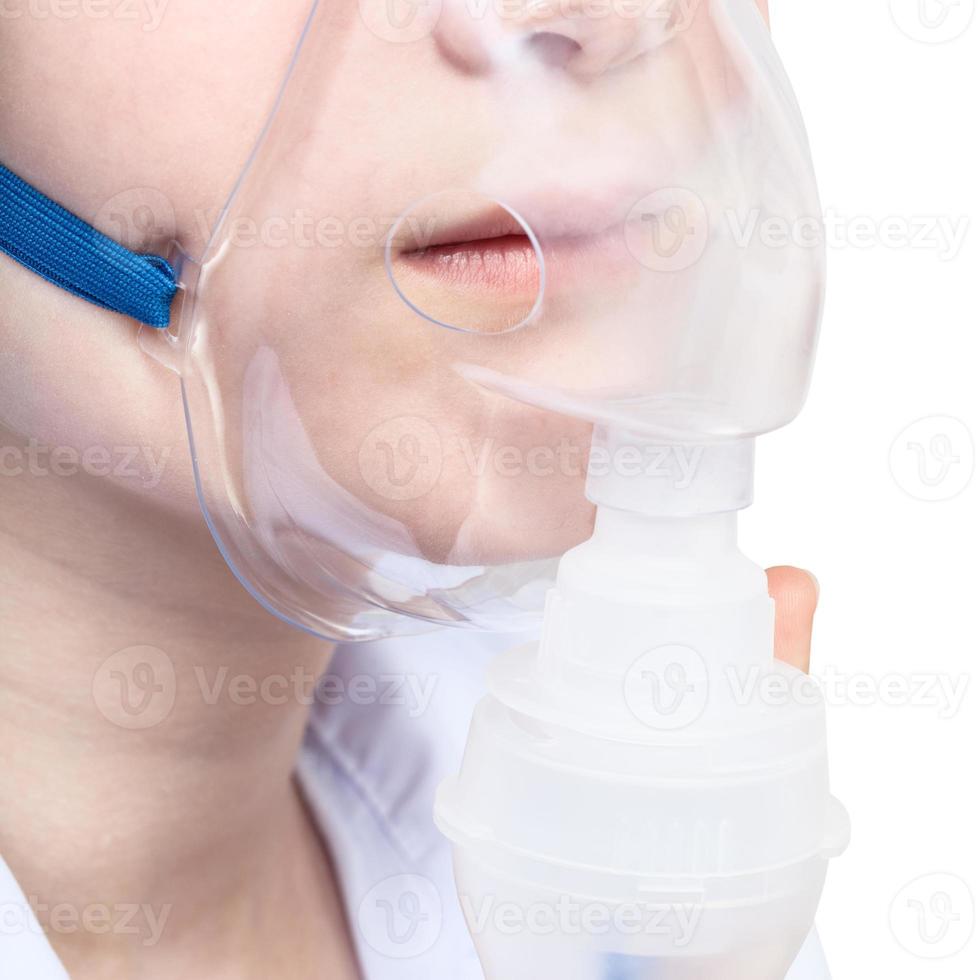 teen inhales with face mask of nebulizer close up photo